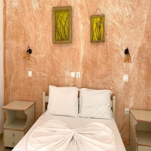 a bedroom with a bed with two stained glass windows at Melissa Chora in Koufonisia