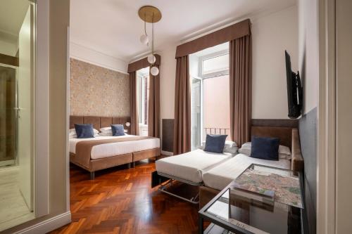 a hotel room with two beds and a table at Vittoriano Suite in Rome