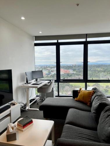 a living room with a couch and a desk with a computer at Premium Apartment with 2 Beds 1 Bath in Melbourne