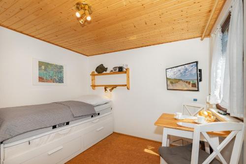 a bedroom with a bed and a desk at Ferienhaus am Strand 92a - Bade- & Saunawelt täglich inklusive in Baabe