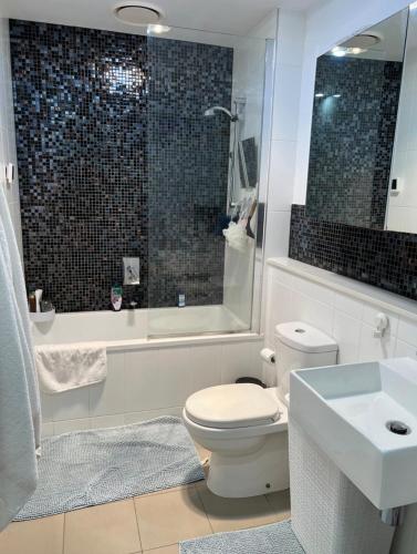 a bathroom with a toilet and a sink and a tub at Premium Apartment with 2 Beds 1 Bath in Melbourne