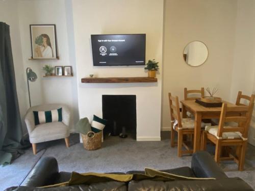 a living room with a tv above a fireplace at Slick Space for a Wigan Stay - 5 Minutes from M6 and M58 Motorways in Pemberton