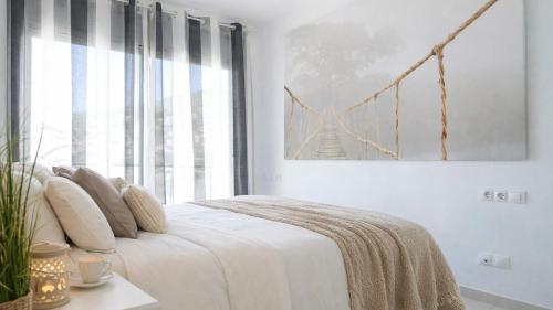 a bedroom with a white bed with a bridge picture on the wall at Spacious Duplex in Sitges with Sea Views, Terrace & Free Parking Area in Sitges