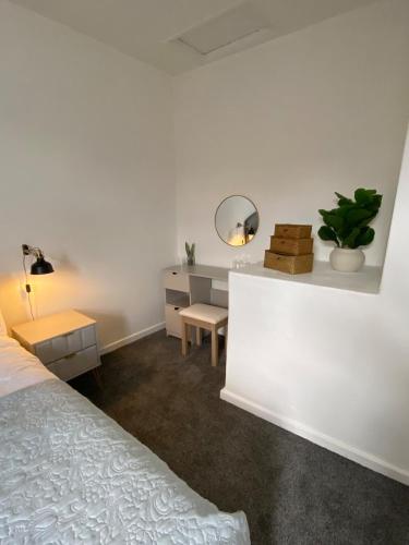 a bedroom with a bed and a desk and a mirror at Slick Space for a Wigan Stay - 5 Minutes from M6 and M58 Motorways in Pemberton