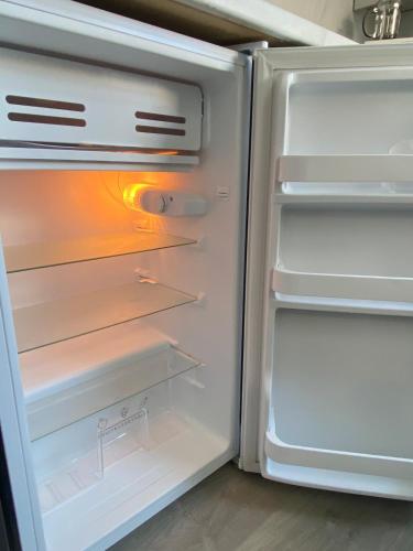 an empty refrigerator with its door open at Slick Space for a Wigan Stay - 5 Minutes from M6 and M58 Motorways in Pemberton