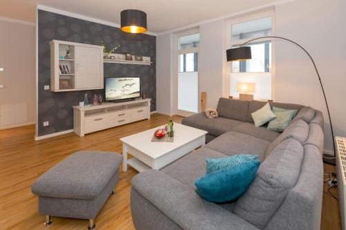 a living room with a couch and a tv at Villa Odin, Muschelsucher - Bade- & Saunawelt täglich inklusive in Ostseebad Sellin
