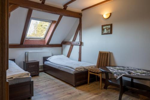 a room with two beds and a table in it at Zajazd Milówka in Węgliniec