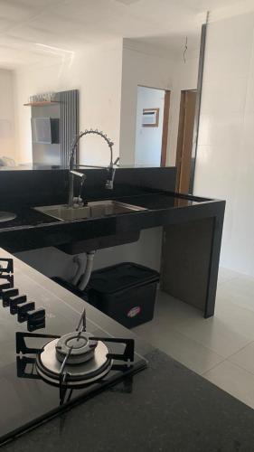 a kitchen with a sink and a counter top at Casa aconchegante com piscina e garagem dupla in Búzios