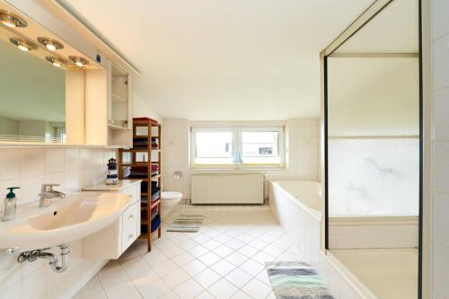 a bathroom with a sink and a tub and a shower at Wietblick in Ockholm