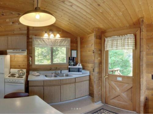 a kitchen with a sink and a refrigerator in a cabin at La Conner Camping Resort Cabin 7 in La Conner