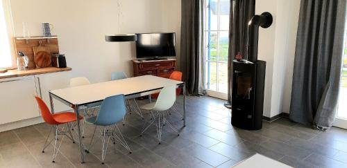 a kitchen with a table and chairs and a refrigerator at Reethaus "Alinde" in Zierow