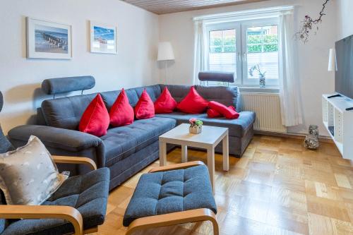 a living room with a blue couch and red pillows at Bungalow Nixe in Tarnewitz