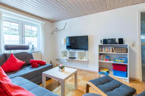 a living room with a couch and a tv at Bungalow Nixe in Tarnewitz