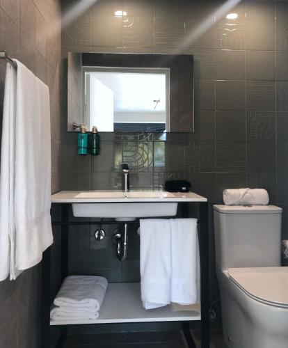 a bathroom with a sink and a toilet at Aura House Isla Verde in San Juan