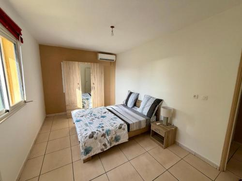a bedroom with a bed sitting on a tiled floor at Apartment with exceptional views, Saint-Joseph in Saint-Joseph