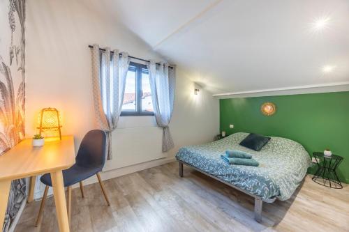a bedroom with a bed and a table and a desk at La Petite Californie - Piscine in Anglet