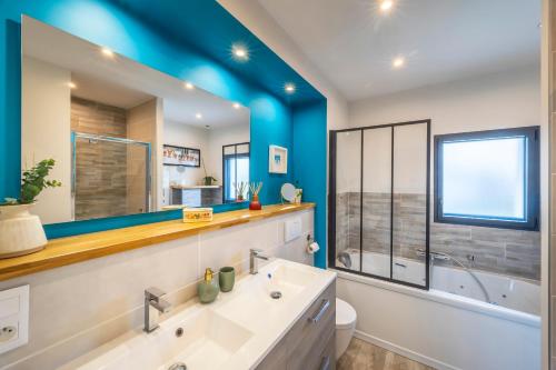 a bathroom with a sink and a mirror at La Petite Californie - Piscine in Anglet