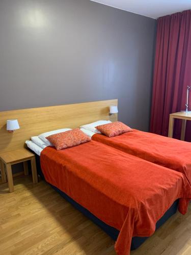 a hotel room with two beds with red sheets at Ruka Chalets 1304 high quality apartment in Kuusamo