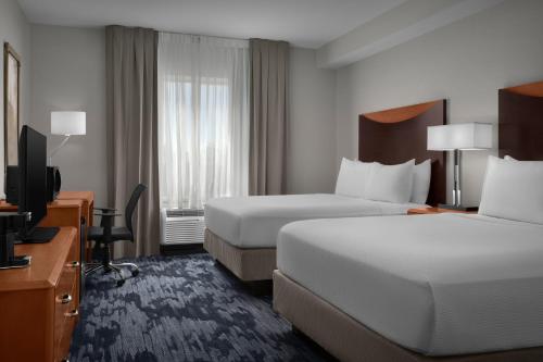 a hotel room with two beds and a flat screen tv at Fairfield Inn and Suites Phoenix Chandler Fashion Center in Chandler