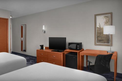 a hotel room with a bed and a desk with a television at Fairfield Inn and Suites Phoenix Chandler Fashion Center in Chandler