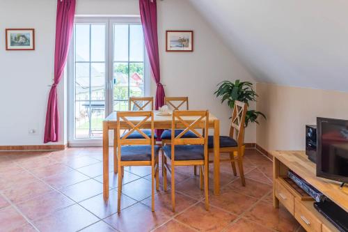 a dining room with a table and chairs and a tv at Ferienwohnung Katharina OG in Wohlenberg
