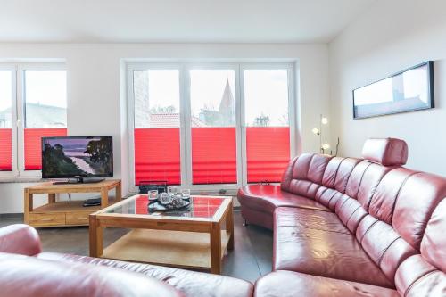 a living room with a leather couch and a coffee table at Ferienwohnung "Colonia" in Klütz