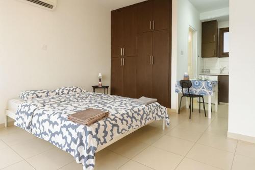 a bedroom with a bed and a table and a kitchen at Old town studio in Limassol