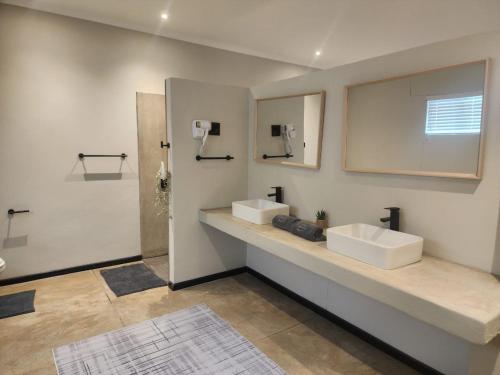 ein Badezimmer mit zwei Waschbecken und einem Spiegel in der Unterkunft Charlen's Rest in Windhoek