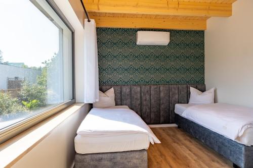 two beds in a small room with a window at PATIO APARTAMENTY in Łagów