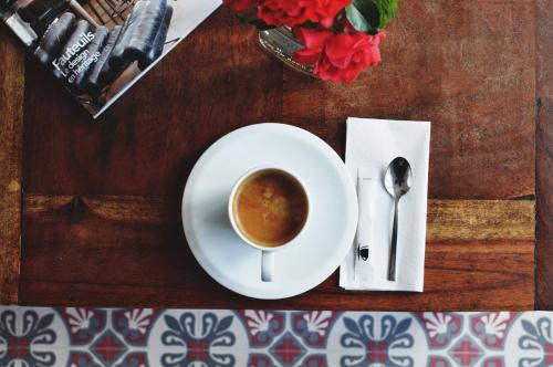 a cup of coffee sitting on a table with a plate at Hôtel de France in Saint-Savin-sur-Gartempe
