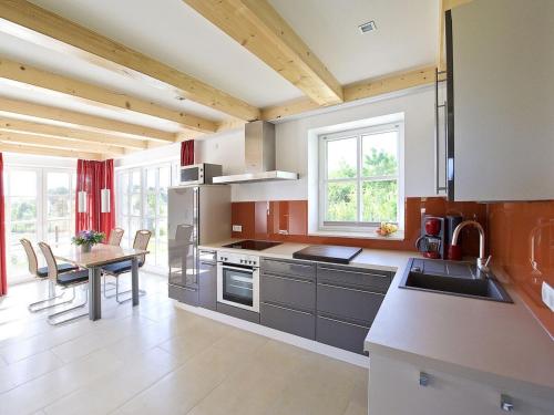 a kitchen with stainless steel appliances and a table at Reethaus Ostseeblick 1 in Wohlenberg