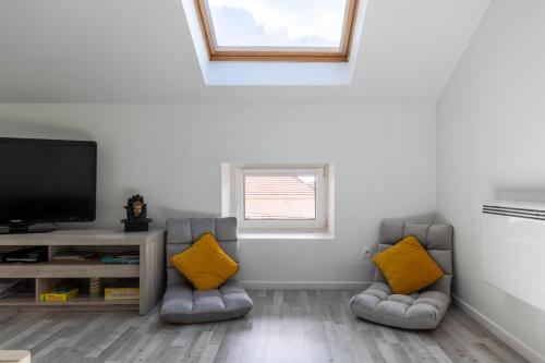a living room with two chairs and a flat screen tv at bel appartement,confortable,2chambres in Briey