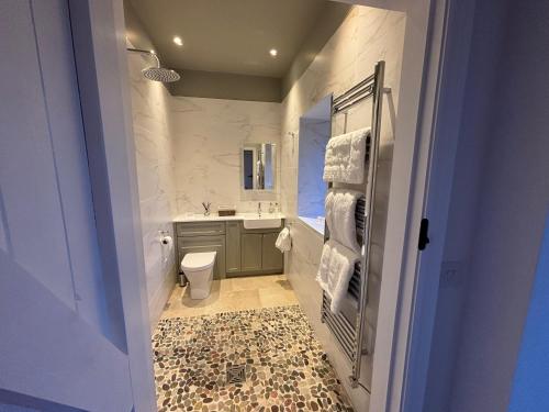 a bathroom with a sink and a toilet and a mirror at Stable Cottage in Lockerbie