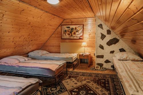 a room with three beds in a wooden cabin at Domek "Kasieńka" in Stronie Śląskie