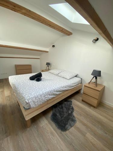 a bedroom with a bed with a black pillow on it at spacious cottage with hot tub in Saint-Martin-dʼArdèche