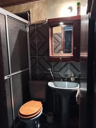 a bathroom with a toilet and a sink and a mirror at Lo de Fabi in La Coronilla