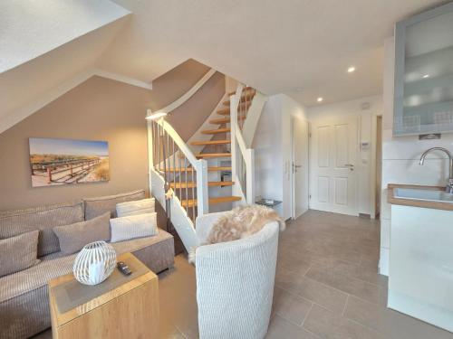a living room with a couch and a staircase at Ferienwohnung Meerglück in Norden