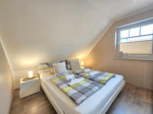 a bedroom with a large bed with a window at Ferienwohnung Meerglück in Norden