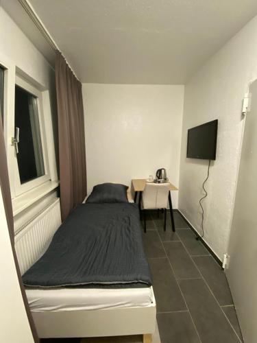 a small bedroom with a bed and a table at Alfa Hotel Frankfurt in Frankfurt