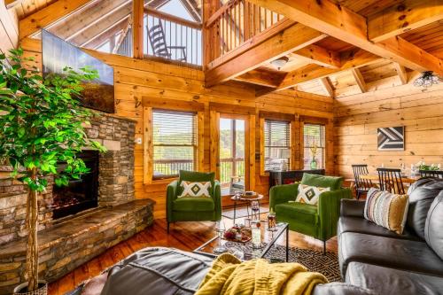 a living room with a stone fireplace and green chairs at Splashtacular: Indoor Pool~Gorgeous Views~HotTub~GameRoom~Resort in Gatlinburg