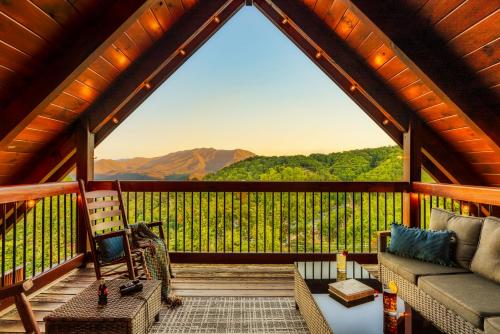 a screened in porch with a couch and a chair at Splashtacular: Indoor Pool~Gorgeous Views~HotTub~GameRoom~Resort in Gatlinburg