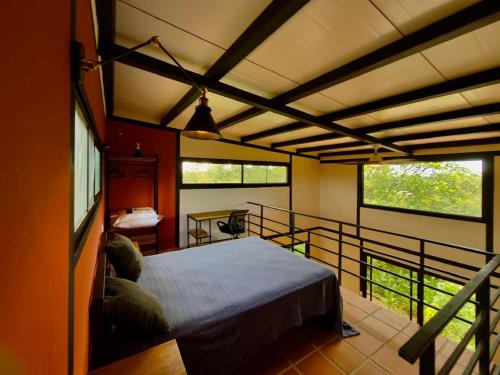 a bedroom with a bed and a balcony with windows at Casa Papaya in Los Chacareños