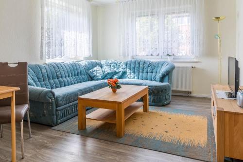 a living room with a blue couch and a coffee table at Ferienwohnung Edda in Klütz