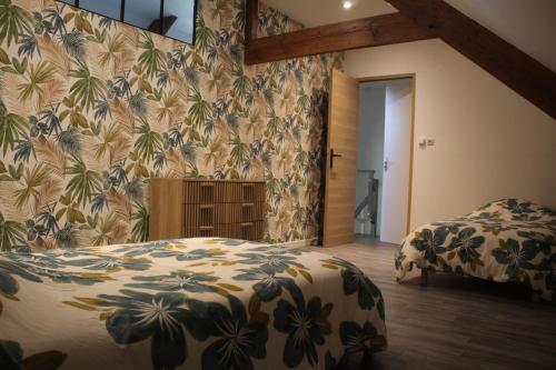 a bedroom with two beds and a floral wallpaper at Le nid des Huttes in Gravelines