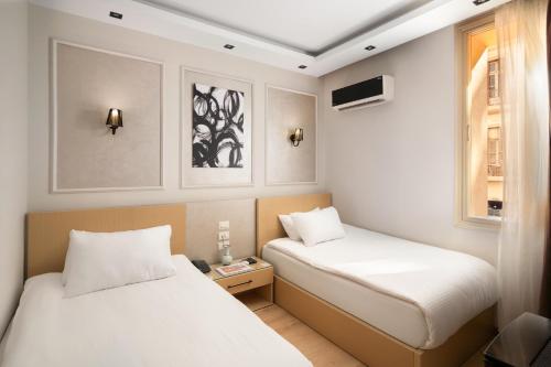 a room with two beds and a window at Cairo Capital Hotel by SK in Cairo