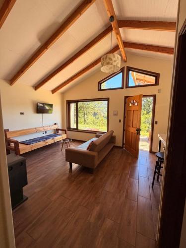 a large living room with a couch and a bed at Cabañas Altos del Sollipulli in Rumiñano