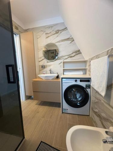a bathroom with a washing machine and a sink at Panoramic Nicolas in Borsa