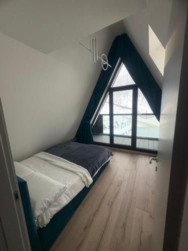 a bed in a room with a large window at Panoramic Nicolas in Borsa