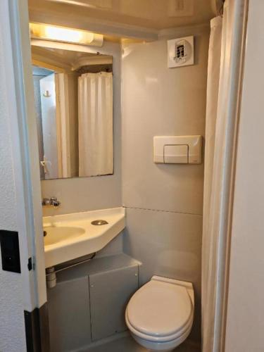 a small bathroom with a toilet and a sink at Premiere Classe Nancy Est Essey in Essey-lès-Nancy