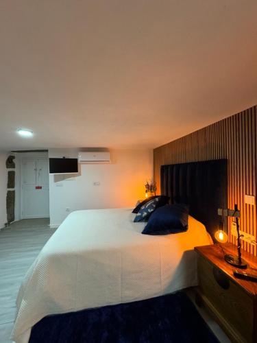 a bedroom with a large white bed and a lamp at Sofiamarholidays O Cantinho da Avó Bina in Moita